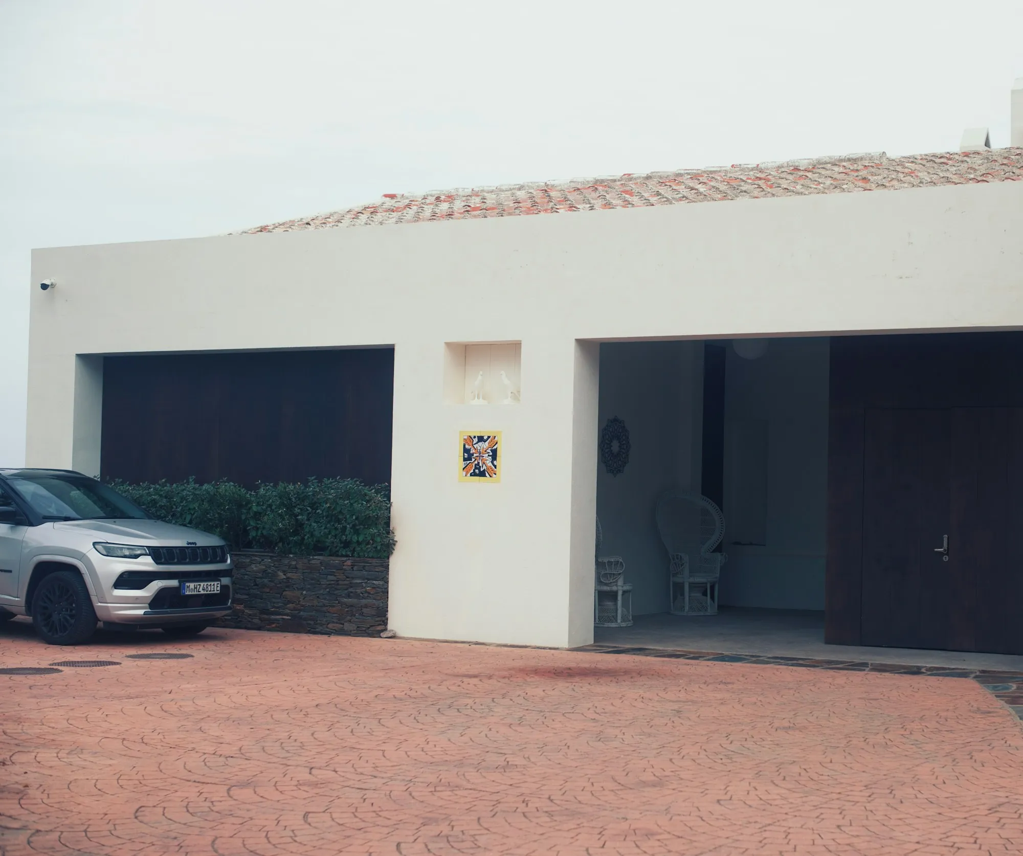 White stucco house with two garage bays and a car outside